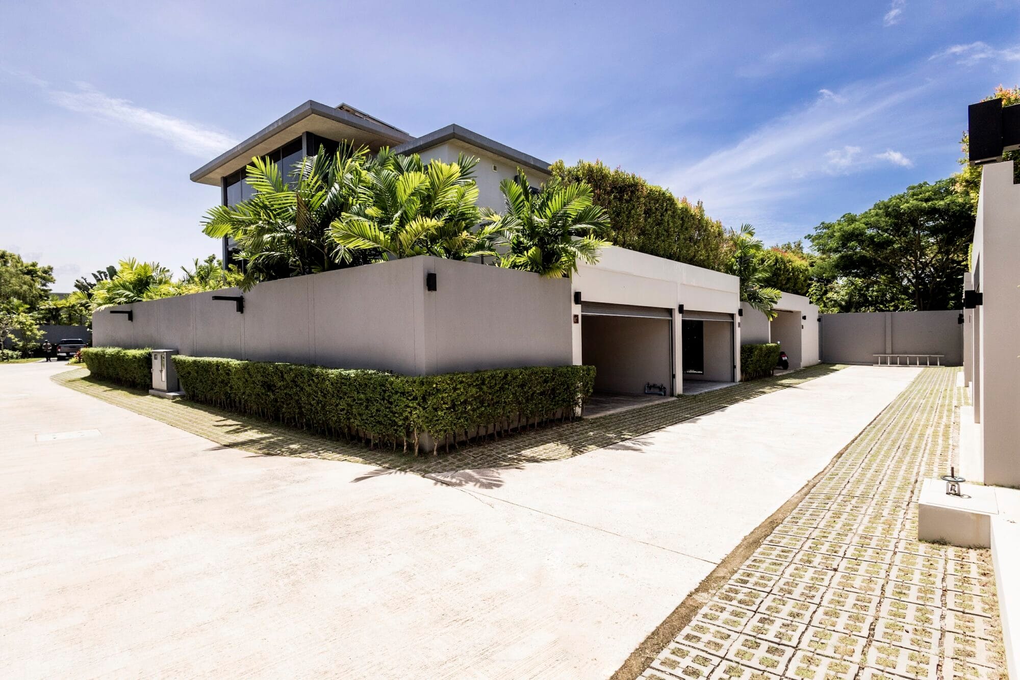 Private villa entrance and covered parking area at RIVERHOUSE Phuket, surrounded by tropical greenery and modern landscaping.