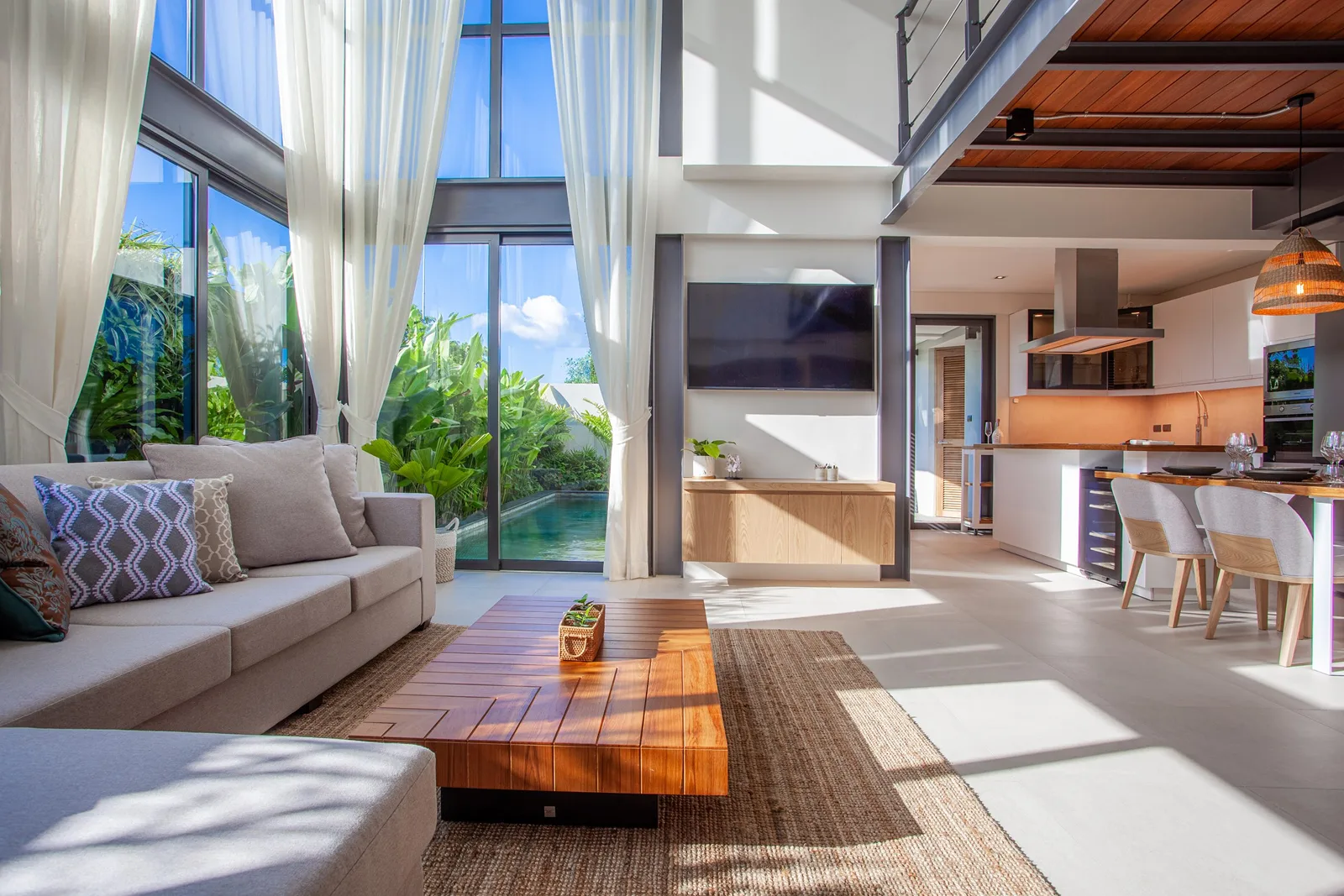 Modern living room with high glass windows and sofa at RIVERHOUSE Phuket villa Title: RIVERHOUSE Phuket – Living Room