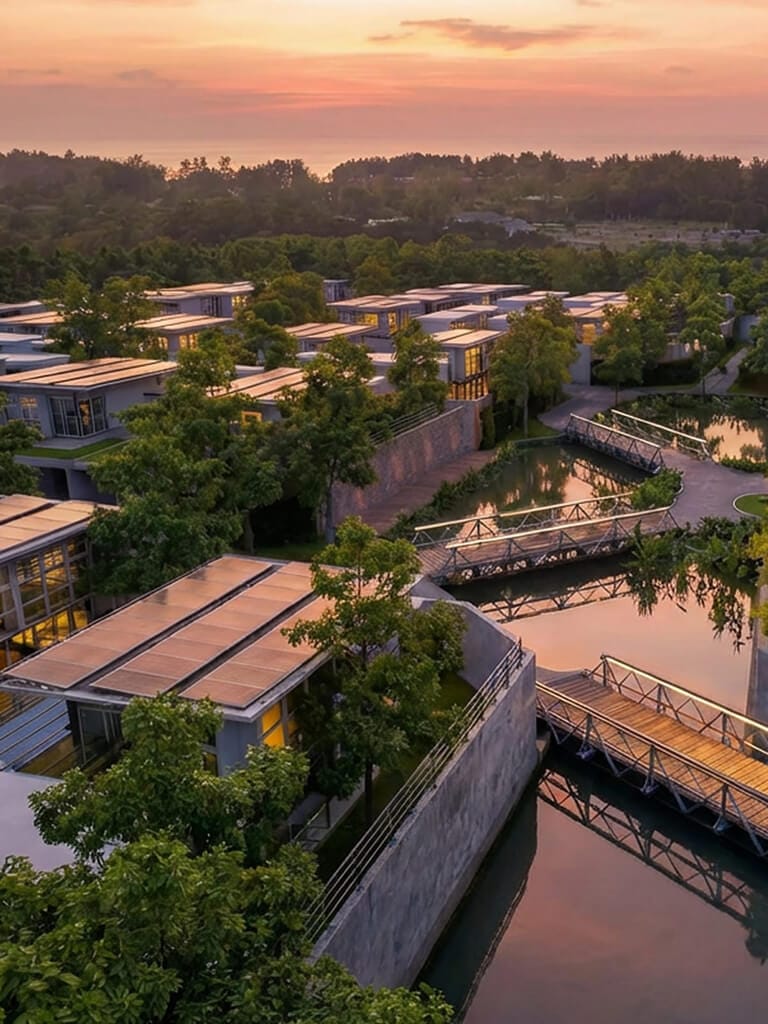 Комплекс вилл RIVERHOUSE Phuket на закате: солнечные панели на крышах, частные бассейны и тропическая зелень вокруг.